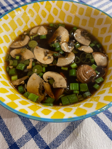 Soupe miso Soupe de champignons avec oignons verts dans un bol coloré.